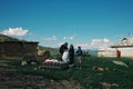 family preparing grain for the chicken next to their yurt high up in the mountains of Alai Range