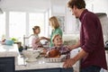 Family Preparing Roast Turkey Meal In Kitchen Together Royalty Free Stock Photo