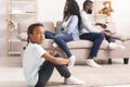 Upset black girl sitting separately from parents after their arguing Royalty Free Stock Photo