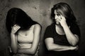 Teenage girl cries next to her angry and worried mother