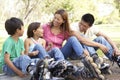 Family Putting On In Line Skates In Park Royalty Free Stock Photo