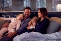 Family In Pyjamas Sitting On Sofa Watching TV Together As Children Fall Asleep Royalty Free Stock Photo