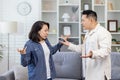 Family quarrel, asian couple man and woman yelling at each other, family conflict, asians at home standing angry in Royalty Free Stock Photo