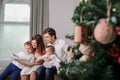 Family is reading a book with christmas fairytales near a christmas tree Royalty Free Stock Photo