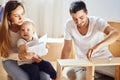 Family reading instruction and assemble furniture together at living room of new apartment pile of moving boxes on Royalty Free Stock Photo