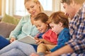 Family, reading and together on couch for learning with happiness, relationship love and rapport. Parents, young