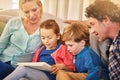 Family, reading and together on couch for teaching with happiness, relationship love and rapport. Parents, young