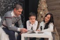 A family reads a book with a child against