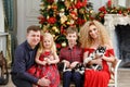 Family in red along with husky puppies sitting on Christmas back Royalty Free Stock Photo