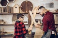 Father and son playing knights with wooden DIY swords at carpenter workshop Royalty Free Stock Photo