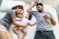 Family relax bedtime togetherness lifestyle concept. Parenthood with their little mixed race daughter sleeping calm together on