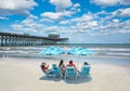 Family relaxing on  the beautiful beach on summer vacation. Royalty Free Stock Photo