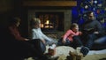 Family relaxing in front of the Christmas tree