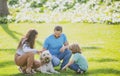 Family relaxing in garden with pet dog. The concept of a happy family. Parents and children on vacation playing together Royalty Free Stock Photo
