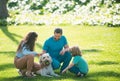 Family relaxing in garden with pet dog. The concept of a happy family. Parents and children on vacation playing together Royalty Free Stock Photo