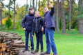 Family relaxing outdoor in autumn city park, happy people together, parent and children, they standing on a log, playing, taking Royalty Free Stock Photo