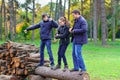 Family relaxing outdoor in autumn city park, happy people together, parents and children, they standing on a log, playing, talking Royalty Free Stock Photo