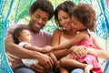 Family Relaxing On Outdoor Garden Swing Seat Royalty Free Stock Photo