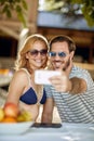 Family relaxing on picnic in nature.Couple enjoying together outdoor and make selfie