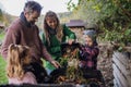 Family removing compost from a composter in garden, and composting kitchen waste in composter. Concept of composting and Royalty Free Stock Photo