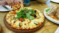 Family in a restaurant. hands take pizza slices from a common dish.