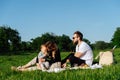 Family resting on a blanket during picnic, feeding crispbreads to the baby Royalty Free Stock Photo