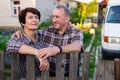 Family of retired farmers together near fence of their homestead