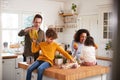 Family Returning Home From Shopping Trip Using Plastic Free Bags Unpacking Groceries In Kitchen Royalty Free Stock Photo