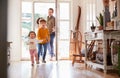 Family Returning Home After Trip Out With Excited Children Running Ahead