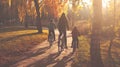 Family riding bicycles together on a park path during a warm autumn sunset, surrounded by golden leaves and trees