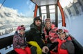 Family riding cabin cable car on winter vacation skiing