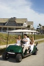 Family riding in golf cart.