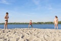 Family on the river bank playing beach volleyball on a sunny, summer day Royalty Free Stock Photo