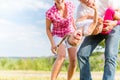 Family romping on field with parents carrying child Royalty Free Stock Photo