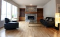 Family room remodeled with solid red oak wooden floors and new furniture. Gas insert fireplace running in background Royalty Free Stock Photo