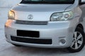 Family roomy auto front side of the toyota porte brand in gray with an automatic door outside in the winter, a minivan prepared