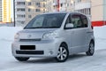 Family roomy auto of the toyota porte brand in gray with an automatic door outside in the winter, a minivan prepared for sale