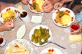 The family at the round table takes food, top view. Lunch dishes: dolma with sauce, mashed potatoes and cabbage Royalty Free Stock Photo