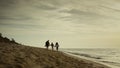 Family running beach landscape. Cheerful people walk together on sand sea coast. Royalty Free Stock Photo