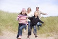 Family running on beach smiling Royalty Free Stock Photo