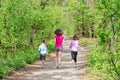 Family running, happy active mother and kids jogging outdoors, run with children in forest, healthy family sport Royalty Free Stock Photo