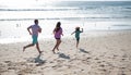 Family running on a sandy beach. Concept of friendly family jogging outdoors. Active parents and people outdoor activity Royalty Free Stock Photo