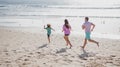 Family running on a sandy beach. Concept of friendly family jogging outdoors. Active parents and people outdoor activity Royalty Free Stock Photo