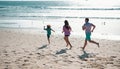 Family running on a sandy beach. Concept of friendly family jogging outdoors. Active parents and people outdoor activity Royalty Free Stock Photo