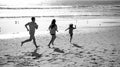 Family running on a sandy beach. Concept of friendly family jogging outdoors. Active parents and people outdoor activity Royalty Free Stock Photo