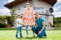 Family With A Sale Sign Outside Their Home