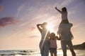 Family on sandy beach near sea, back view