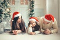 Family with Santa hat lying near Christmas tree, holiday celebration concept Royalty Free Stock Photo