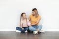 Family Savings. Happy Young Mother And Cute Little Girl Holding Piggy Bank Royalty Free Stock Photo