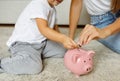 Family Savings. Mother And Daughter Inserting Coins To Piggy Bank At Home Royalty Free Stock Photo